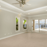 Empty room with ceiling fan and waterfront view