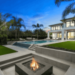 Luxury home with pool and fire pit at sunset