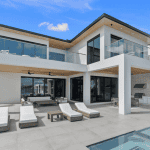 Modern luxury villa with pool and sun loungers.