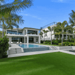 Modern beachfront mansion with pool and palm trees